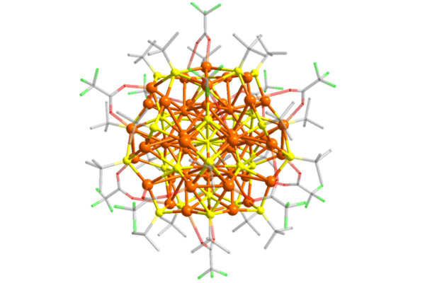 Three-dimensional ball-and-stick model of a large polyhedral inorganic cluster with an orange-yellow core and surrounding gray and green substituents.