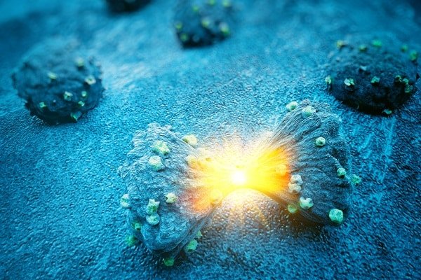 Blue coral formations on the ocean floor with a bright yellow bioluminescent glow at the center of one formation
